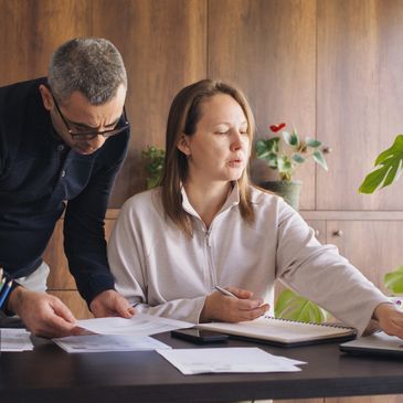 Two colleagues reviewing documents together in a cozy office space.