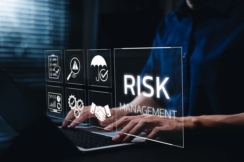 Corporate risk management strategy concept. A businessman is analyzing a virtual risk management interface with critical strategy icons on a laptop screen. Analyze risk assessment, analysis financial,
