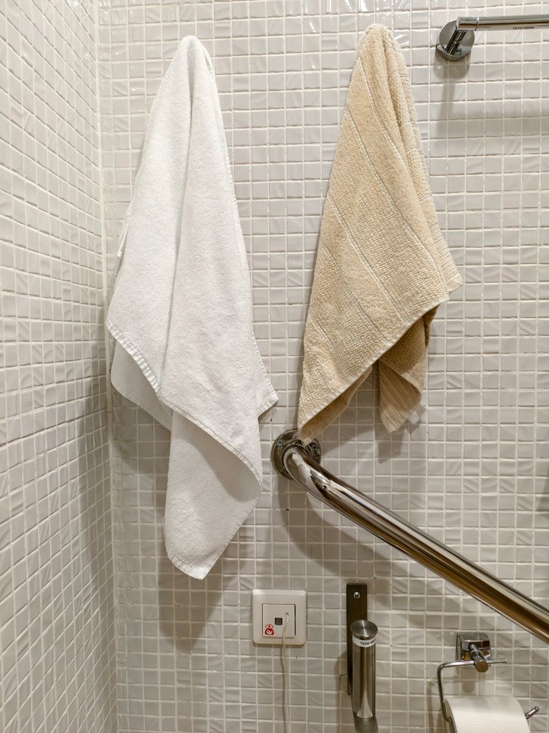 Clean waffle-weave towels hang neatly from a metallic rod in a bathroom