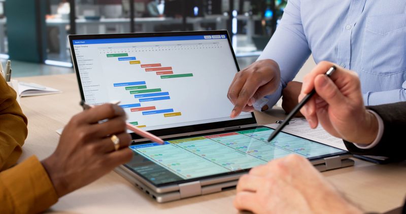 Young Woman Uses Agenda Software On Tablet, Managing Team Workflow. An Office Manager Reviews Gantt Chart