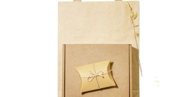 Rustic stationery with a small tied envelope on a cardboard box.