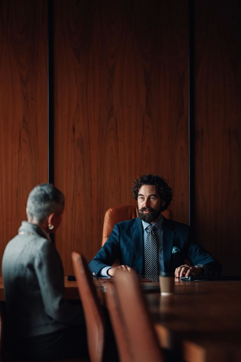 Business partners engaging in a serious discussion, planning strategy, or conducting an interview in a sophisticated boardroom