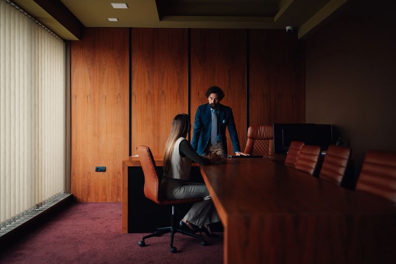 Professionals having a serious discussion during a business meeting in a modern office boardroom, addressing challenges