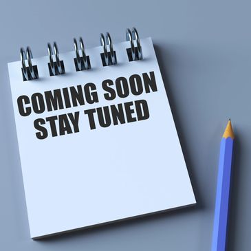 Notebook with "COMING SOON STAY TUNED" text and pencil.