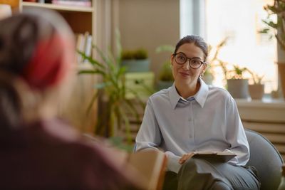Therapist listens attentively to patient in a cozy office.