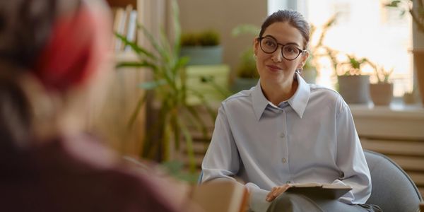 Therapist listening attentively to patient in a cozy office.