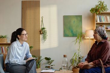 Two women sitting on the chair with discussing each other