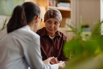 A doctor comforting a patient wearing a headscarf.