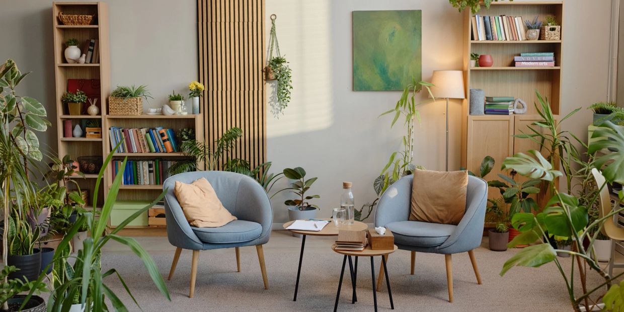 Cozy sitting area with blue chairs and plants.