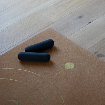 Two black cylindrical objects on a cork surface.