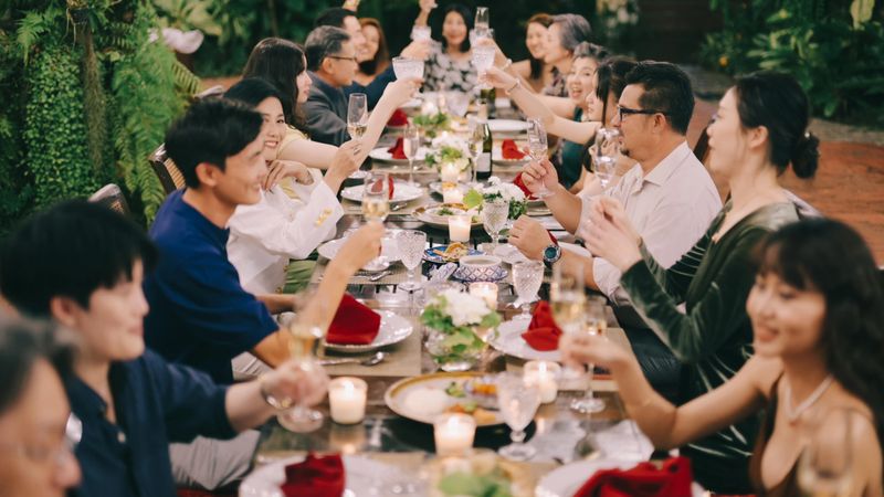 group of asian adults enjoying dinner together, expressing togetherness, conversation, and social balance through communal dining experience. lifestyle footage emphasizing shared meals, emotional connection, and human interaction within relaxed