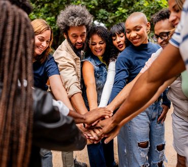 Group hands together showing unity.