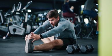Man stretching in gym for muscle recovery