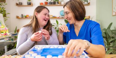Two women happily painting pottery together.
