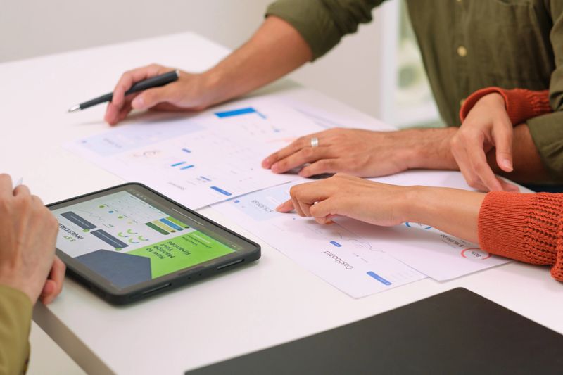 close up Financial advisor consulting a couple during a personal finance meeting, talking through mortgage, investment, loan, and insurance planning using a digital tablet