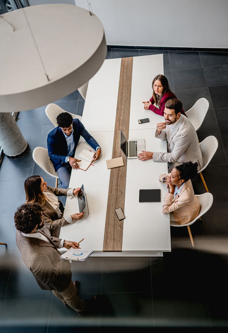 Diverse group of young adult business people collaborating on strategy during a corporate meeting in modern office setting