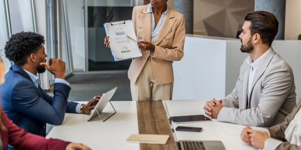 Businesswoman presenting to colleagues in a meeting room.