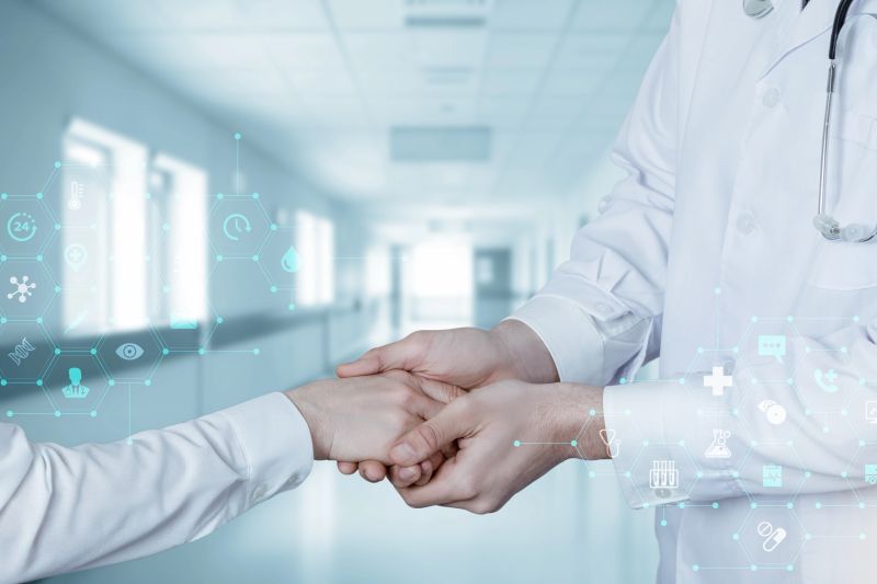 A doctor and patient shake hands, symbolizing trust and hope in a clean clinic.