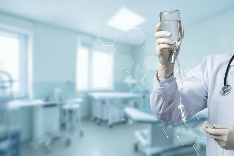 A dedicated nurse holds an IV bag, ready to assist patients in a bright clinic.