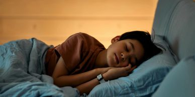 A boy peacefully sleeping on a bed.