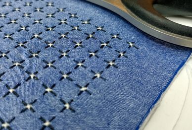 Close-up of patterned blue fabric with scissors.