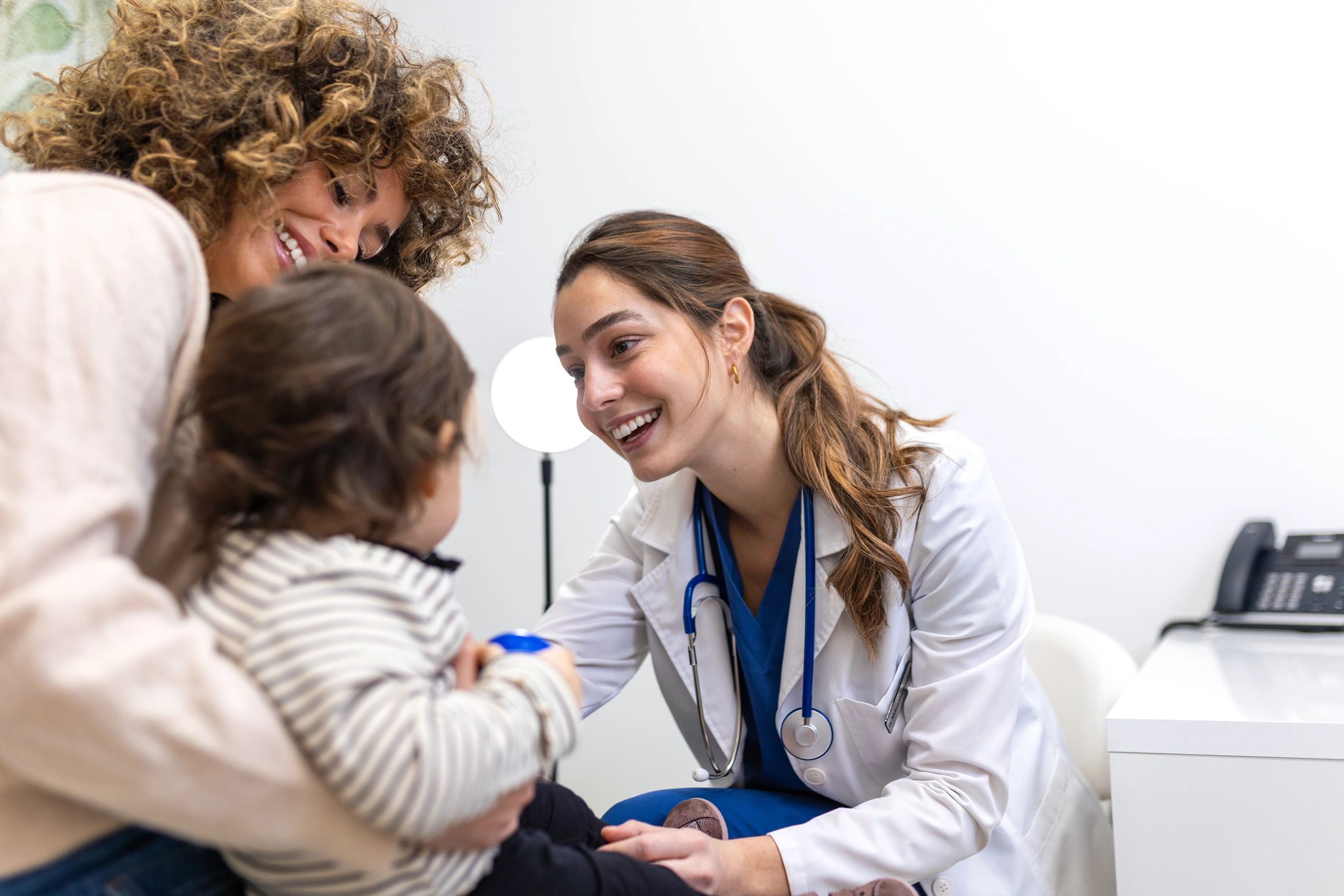 Pediatric clinician speaking with a parent and child