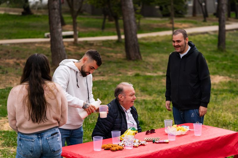 Group of people enjoying food and conversation at an outdoor picnic table