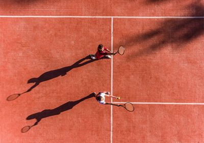 Aerial view of two tennis players on a clay court.