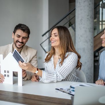 Couple discussing solar energy options using a house model.