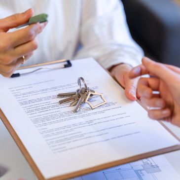 Keys on contract with two people exchanging keys.