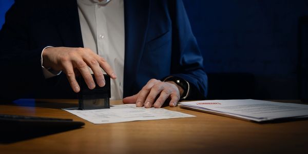 Person stamping documents at a desk.