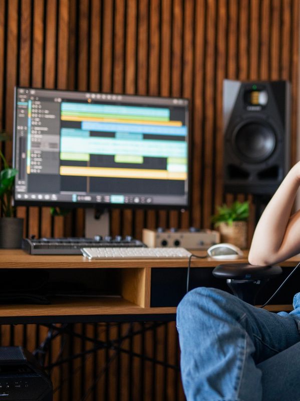 Person working on music production at a studio desk.