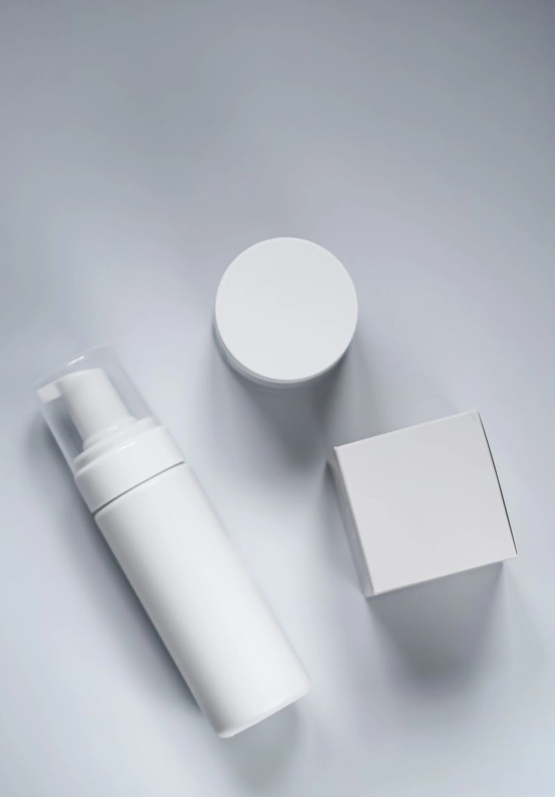 White cosmetic product packaging for skincare and beauty mockups. Flat lay showing a pump bottle, cream jar, and box
