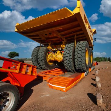 Heavy-duty dump truck loading onto trailer.