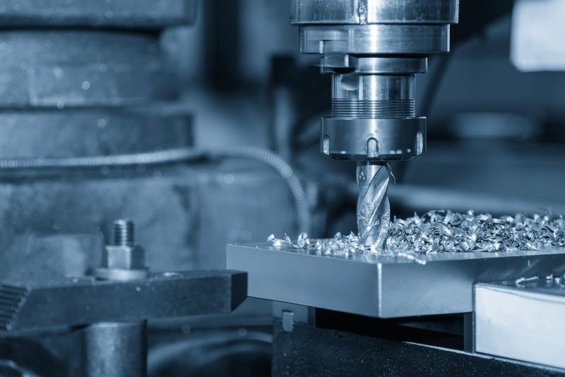 The high-precision boring process executed on a heavy metal plate using an NC (Numerical Control) milling machine (CNC machining center). The operation utilizes a rigid flat nose end mill tool, acting as a boring bar, to enlarge and finish an existing hole to an exact diametrical dimension and superior surface finish