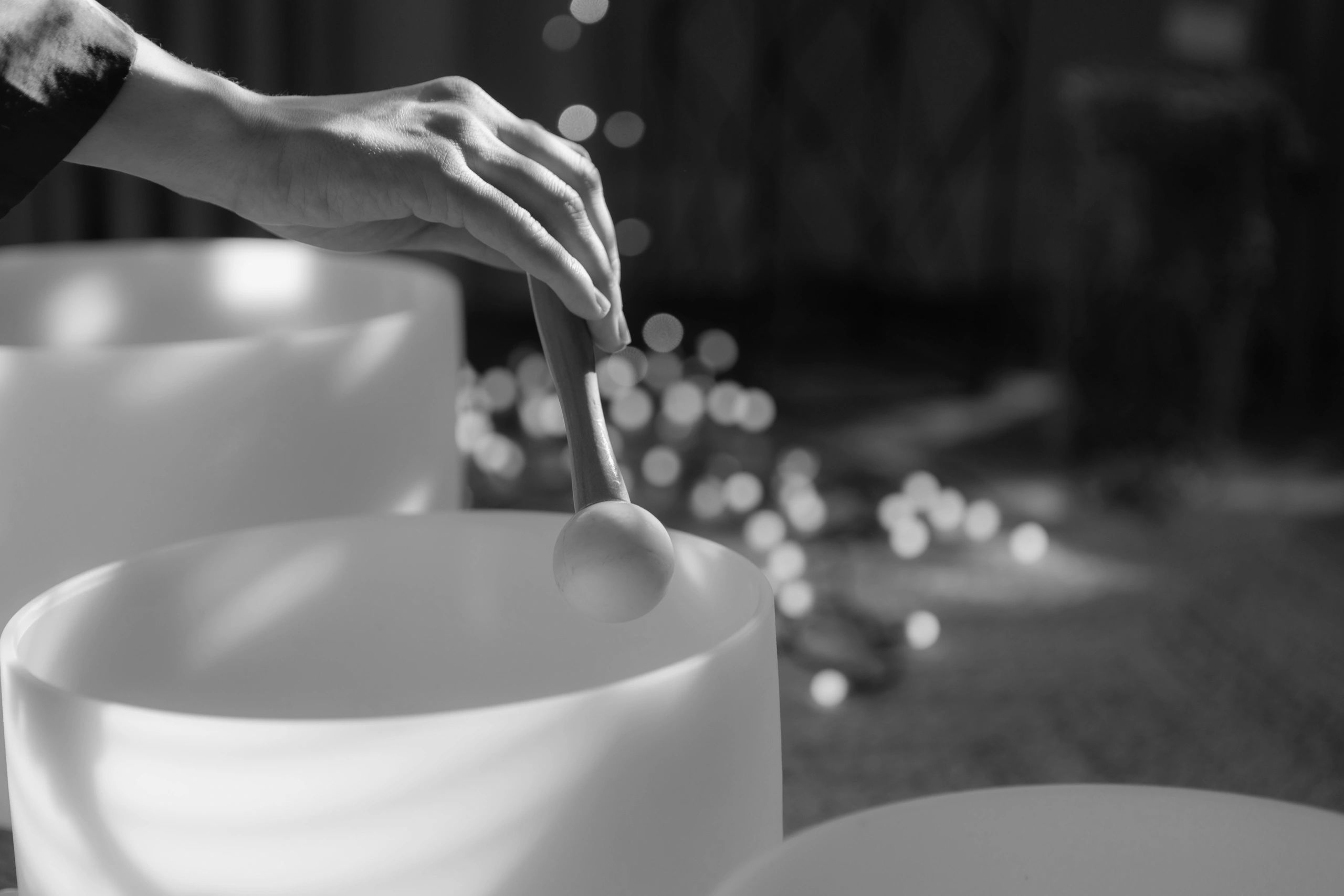 Hand holding mallet near white bowl.