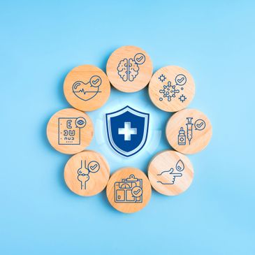 Wooden blocks with health icons surrounding a shield symbol on blue background.