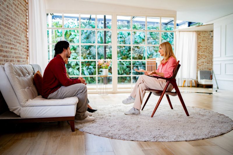 Mature psychotherapist woman talking to couple during psychotherapy session