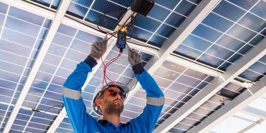Technician inspects solar panel wiring using a multimeter.