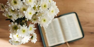 White flowers with an open book blurred in the background.