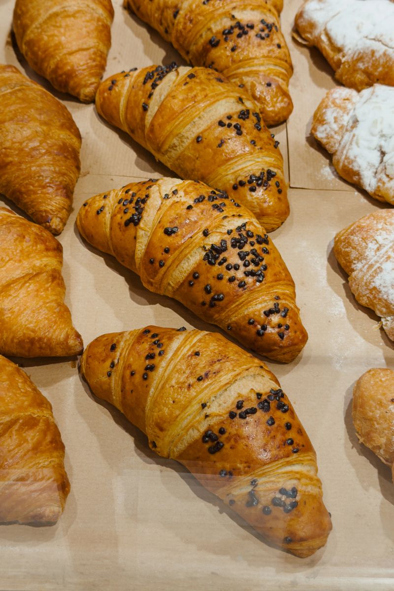 Warm, flaky pastry with rich chocolate chips resting on brown parchment paper.