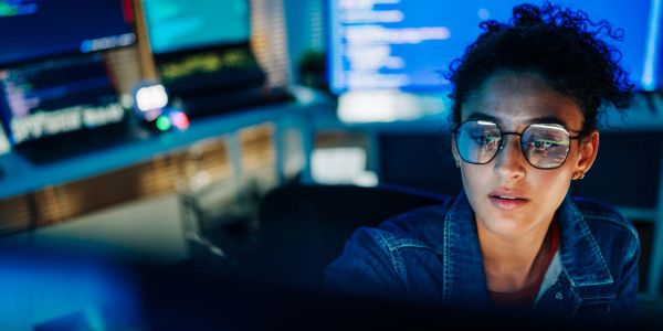 Woman working with computers in a tech environment.