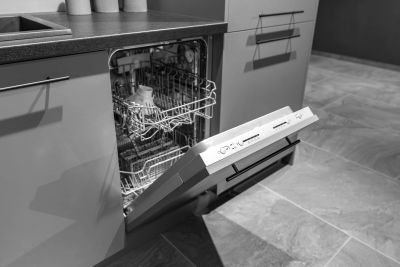 Open dishwasher in kitchen with dishes inside.