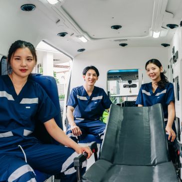 Three medical professionals inside an ambulance.
