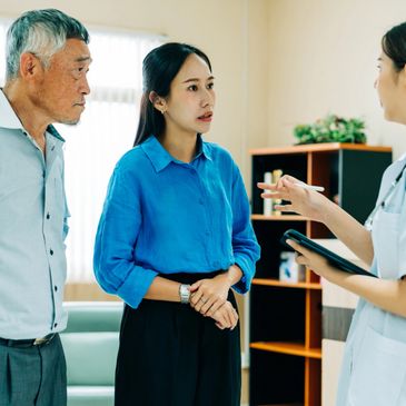 A doctor discusses health concerns with a worried woman and an older man.