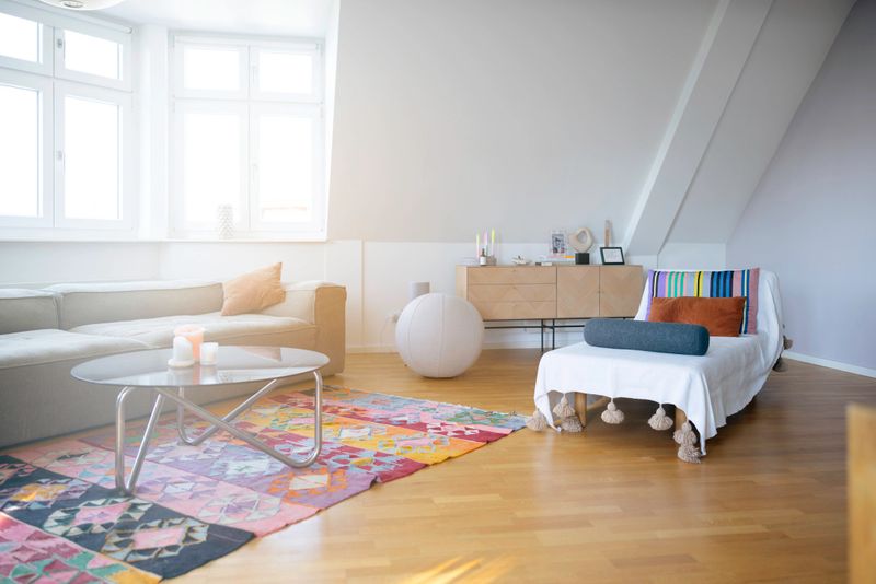 Modern living room interior featuring a comfortable sofa, coffee table, and bright window light creating a cozy atmosphere.