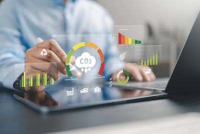 Person using tablet to analyze CO2 and sustainability data.