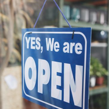 Blue sign saying "YES, We are OPEN" hanging.