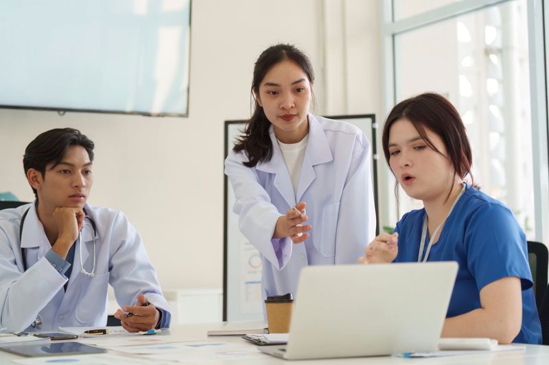 A healthcare team collaborates on patient care solutions, utilizing technology and data during a productive meeting.