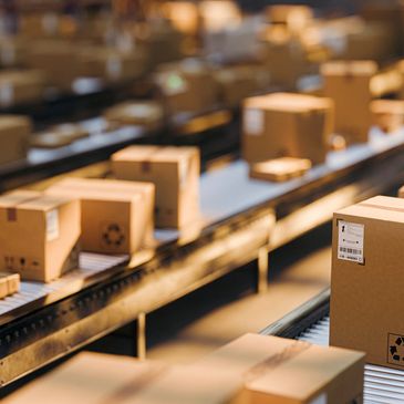 Conveyor belts transporting cardboard packages in a warehouse.